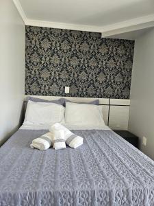 a bedroom with a bed with two towels on it at Família sperandio in Balneário Camboriú