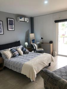 a bedroom with a bed and a chair and a window at Escápate a Manta Piscina y Confort in Manta