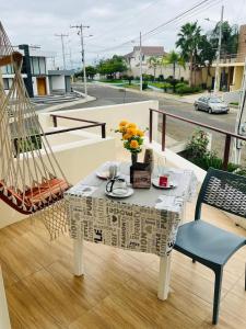 a table with a vase of flowers on a balcony at Escápate a Manta Piscina y Confort in Manta