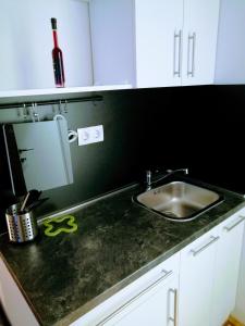 a kitchen counter with a sink and white cabinets at Pula-Center Studio Apartments in Pula +49 photos