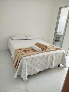 a bedroom with a bed with a blanket and a mirror at Casa Praia de Conceição Barra-ES in Conceição da Barra