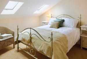 ein Schlafzimmer mit einem Bett mit weißen Laken und Kissen in der Unterkunft Damson Cottage in Rainow