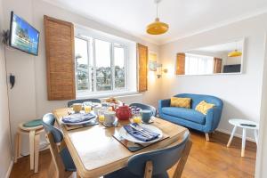 a dining room with a table and a blue chair at Oyster Catcher Cottage - Harbour Bowl, Sea Views in Brixham
