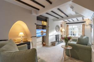 a living room with a couch and a tv at Oyster Catcher Cottage - Harbour Bowl, Sea Views in Brixham