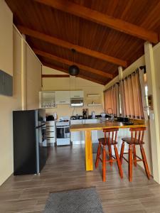 a kitchen with a large wooden table and chairs at Villa Lomas Sarapiquí in Colonia Carvajal +17 photos