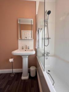 a bathroom with a sink and a tub and a mirror at The Monsal in Monsaldale Station