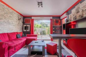 a living room with a red couch and a table at Appartement Zen - Cavalaire-sur-mer - Résidence Privée in Cavalaire-sur-Mer