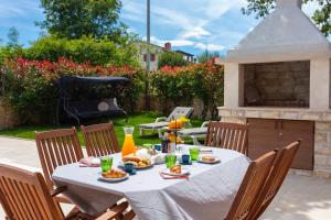a table with food on it in a backyard at Villa La Vita in Čabrunići +35 photos