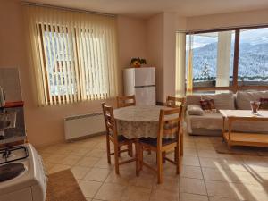 a kitchen and living room with a table and chairs at Panorama Stoykite Yana apartment in Pamporovo