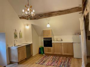 a kitchen with wooden cabinets and a chandelier at Chez TESS in Saint-Félix