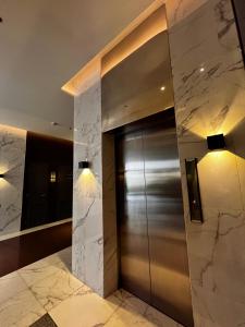 a elevator in a building with marble walls and lights at Kasara Serenity Condotel in Manila
