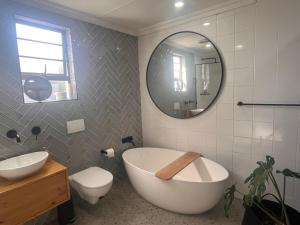 y baño con bañera, aseo y espejo. en Nahoon View, King Room, en East London 13 fotos más