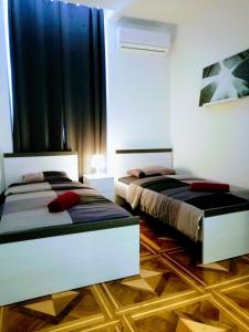 two beds in a bedroom with black curtains at Pula-Center Studio Apartments in Pula