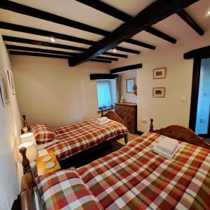 una camera da letto con due letti in una stanza di Oakside Cottage Braithwaite a Braithwaite