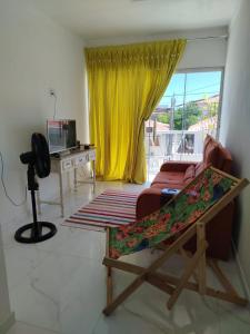 a living room with a couch and a yellow curtain at Casa Praia de Conceição Barra-ES in Conceição da Barra +11 photos