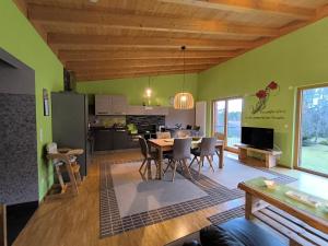 a living room with a dining table and a kitchen at Ferienhaus Brütting in Pottenstein