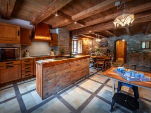 een keuken met houten kasten en een bakstenen muur bij La Ferme du Cortet - OVO Network in Thônes