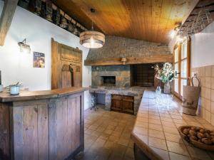 een grote keuken met een stenen open haard en een tafel bij La Ferme du Cortet - OVO Network in Thônes +21 foto's