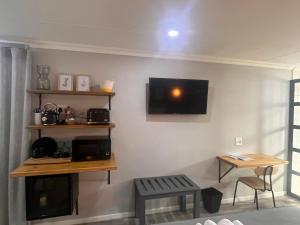 Una sala de estar con un televisor en la pared. en Nahoon View, King Room, en East London