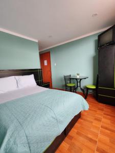 a bedroom with a large bed and a table at Catag Wasi Casa hospedaje in Cajamarca