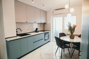 a kitchen with white cabinets and a table with chairs at Exclusiv Est One in Drobeta-Turnu Severin