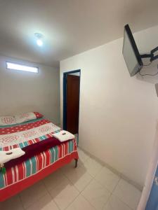a bedroom with a bed and a tv on the wall at Hotel San Vicente in Darién