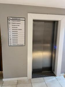 a elevator door with a sign on the wall at Suíte premium de alto padrão II - Climatizado in Feira de Santana +31 photos
