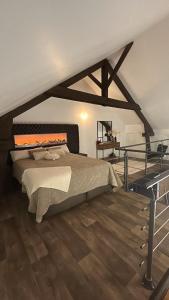 Un dormitorio con una cama y suelo de madera. en Love Room Spa - Sauna - Hammam, en Domérat