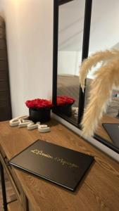 a table with a mirror and red flowers on it at Love Room Spa - Sauna - Hammam in Domérat +6 photos