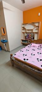 a bedroom with a pink bed with cows on it at Sri Annai Home Stay I in Tiruvannāmalai