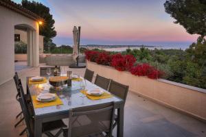 ein Tisch auf einer Terrasse mit Blick auf das Meer in der Unterkunft FRGK " Villa de rêve avec vue mer sur le Cap d Antibes " in Vallauris