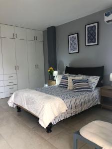 a bedroom with a bed and white cabinets at Escápate a Manta Piscina y Confort in Manta