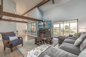 a living room with a couch and a tv at Sunshine Lagoon in Sanibel