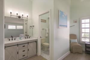 a bathroom with a sink and a toilet and a mirror at Sunshine Lagoon in Sanibel +33 photos