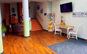 a room with a staircase and a table and a refrigerator at Best Western Spreewald in Lübbenau