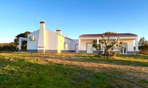 a white house with a tree in front of it at Monte da Lebrinha in Vila Alva