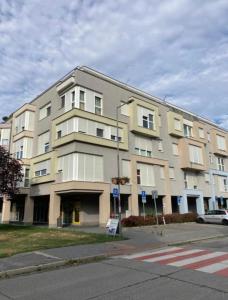 a large building on the corner of a street at Central AREA Cozy Apartment in Šamorín