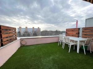 a patio with a table and chairs on a balcony at Central AREA Cozy Apartment in Šamorín +2 photos