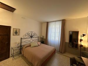 a bedroom with a bed and a large window at L'Altro Sapore Rooms in Pitigliano