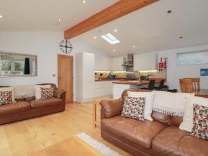 un soggiorno con 2 divani marroni e una cucina di 2 Miller's Island a Looe