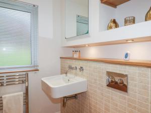 un bagno con lavandino e specchio di 2 Miller's Island a Looe Altre 22 foto