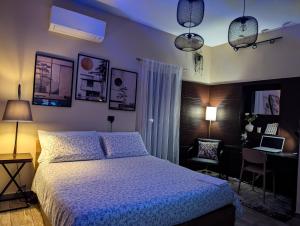 Un dormitorio con una cama y un escritorio con una computadora portátil. en Thiago Luxury Home, en Catania