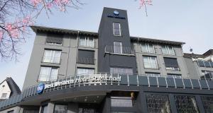 莫尔巴赫Best Western Hotel St. Michael的一座大型灰色建筑,上面有标志