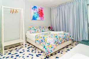 a bedroom with a bed with a colorful bedspread at Mini departamento a una cuadra de la playa y de la bahia de Bocagrande in Cartagena de Indias
