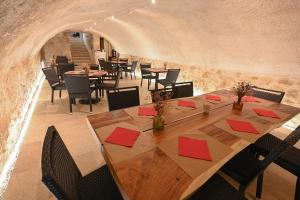 a dining room with a long table and chairs at Hotel De La Croisée in Poncin