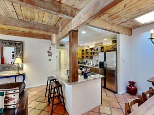 a kitchen with wooden ceilings and a counter with stools at Artist Road #7 in Santa Fe +16 photos