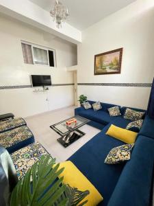 a living room with a blue couch and a table at Cente ville House in Agadir +9 photos