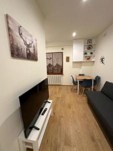 un soggiorno con una TV a schermo piatto su una parete di Casa Vacanza Piccolo Chalet a Roccaraso