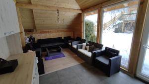 a living room with black furniture in a cabin at Penzión u Marlenky in Spišská Stará Ves