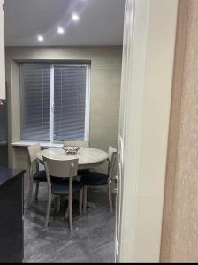 a dining room with a table and chairs and a window at New design apartment in Rustavi